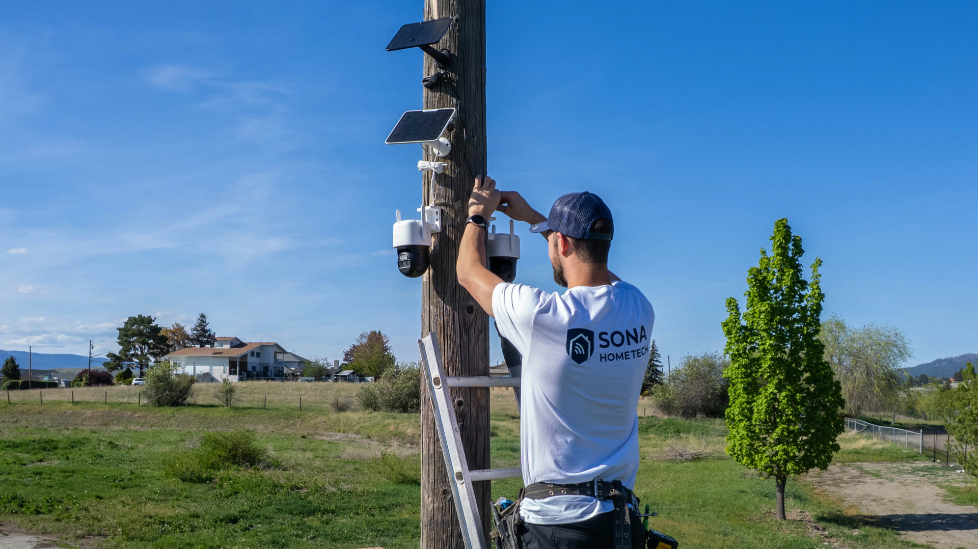 Sona HomeTech technician installing pole-mounted security cameras